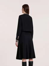 the back view of a lady in black jacket with black a-lined midi skirt